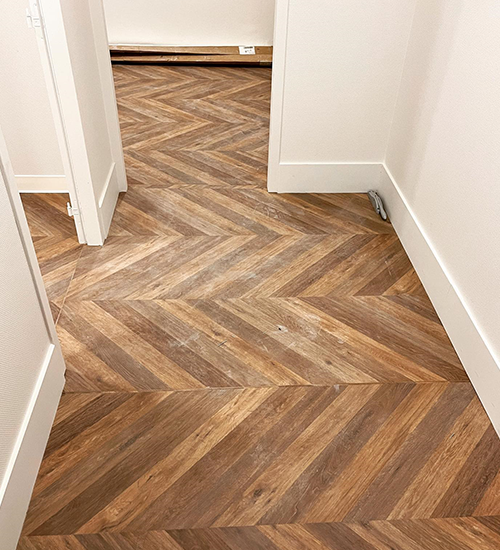Couloir parquet chevron chaleureux posé par jordan harkat, spécialiste sols à montauban
